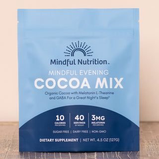 A resealable pouch of Mindful Nutrition Mindful Evening Cocoa Mix, with blue and white packaging, indicating the product is sugar free, dairy free, and non-GMO.