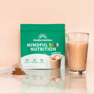 A resealable pouch of GoMindfully Orange drink mix by Mindful Nutrition, with a glass and scoop.
