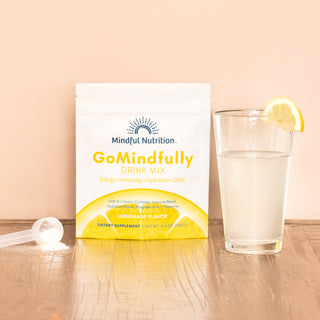 Mindful Nutrition GoMindfully Lemonade Drink Mix pouch with hydration powder and a glass of water garnished with a lemon slice